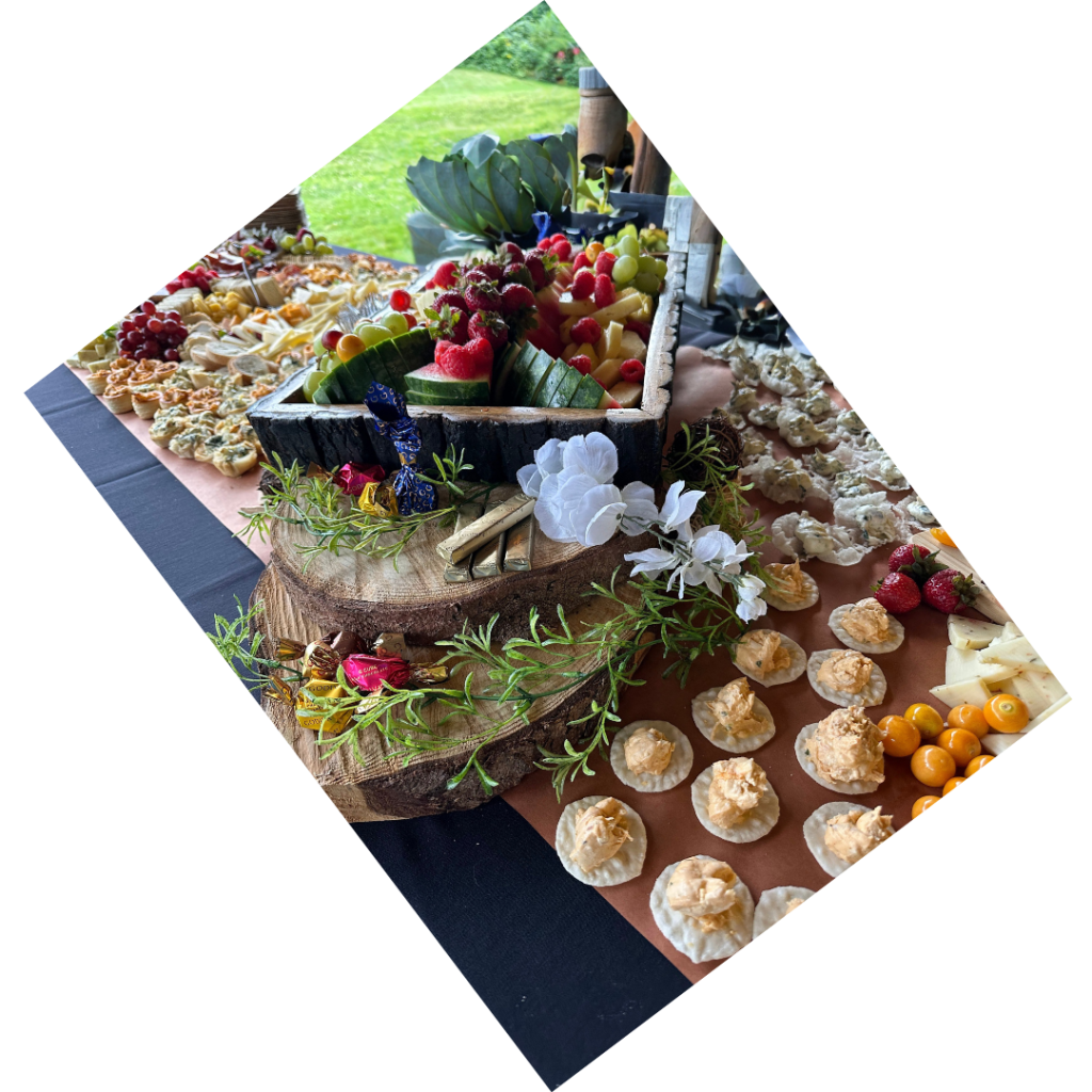 A vibrant and diverse cheese and fruit platter arranged on a wooden board for an event.