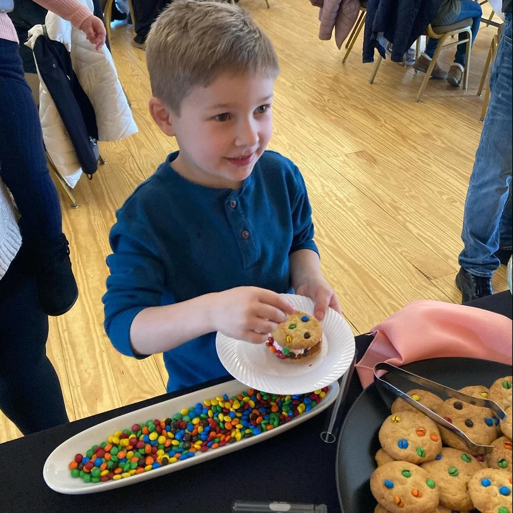 A happy boy building a custom ice cream sandwich.